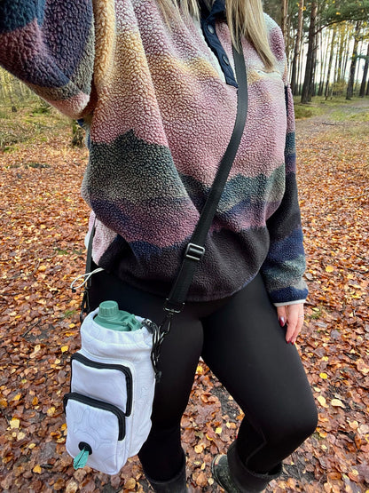 Dog owner wearing Contour Trail Bottle Bag crossbody during outdoor walk