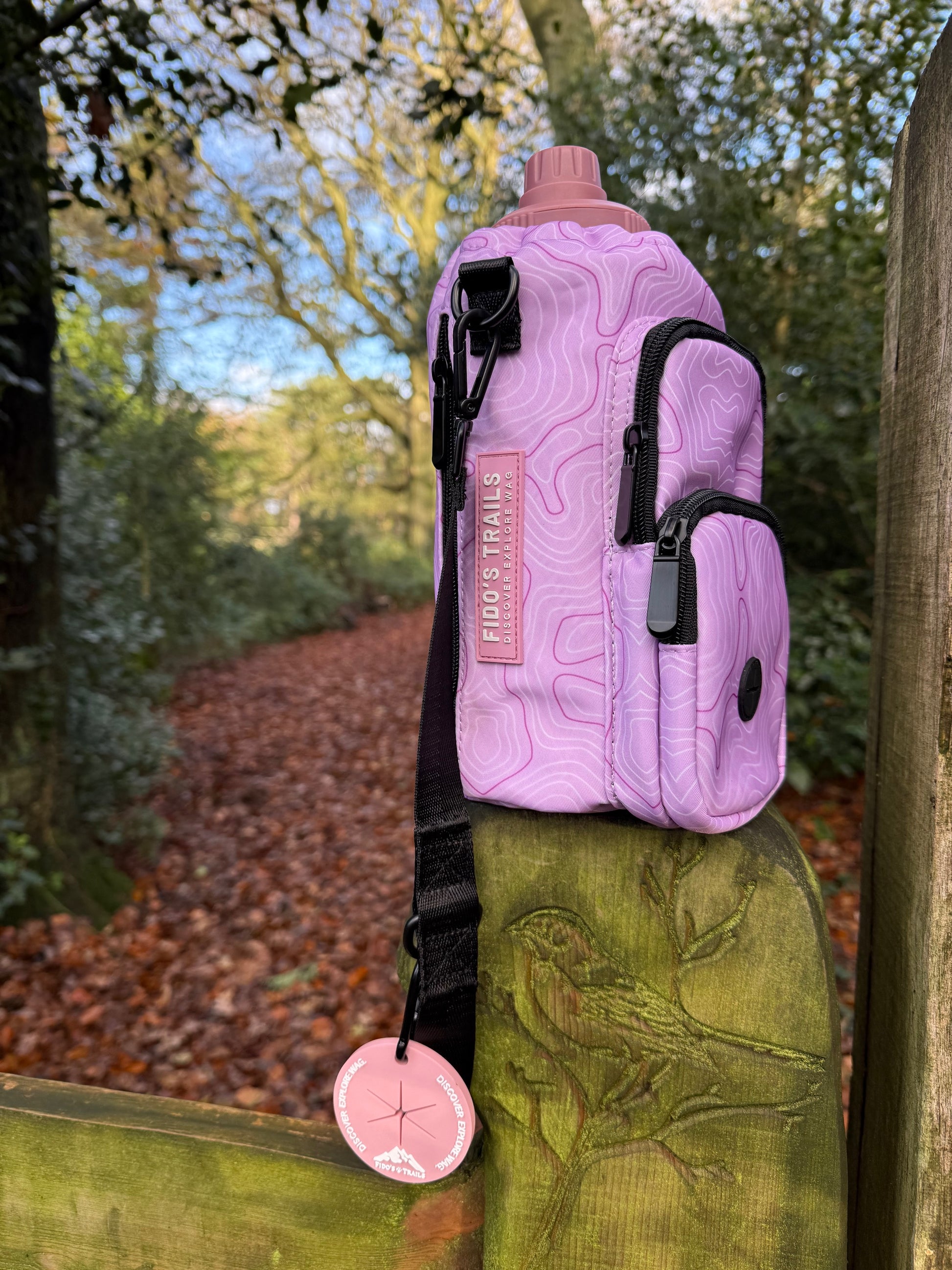 Pink Contour Trail Bottle Bag displayed outdoors for dog walking
