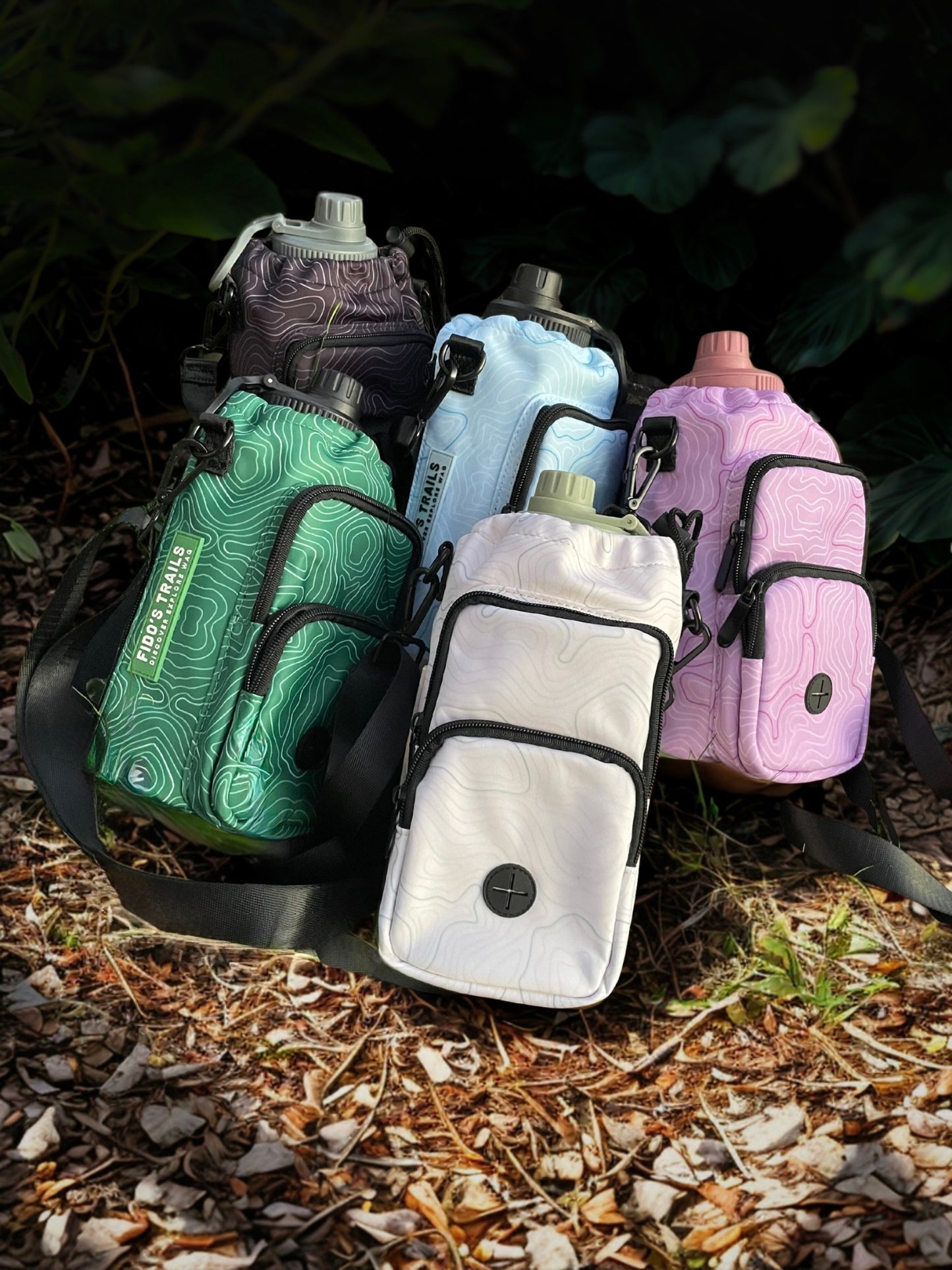 Contour Trail Bottle Bag in multiple colours displayed outdoors for dog walking