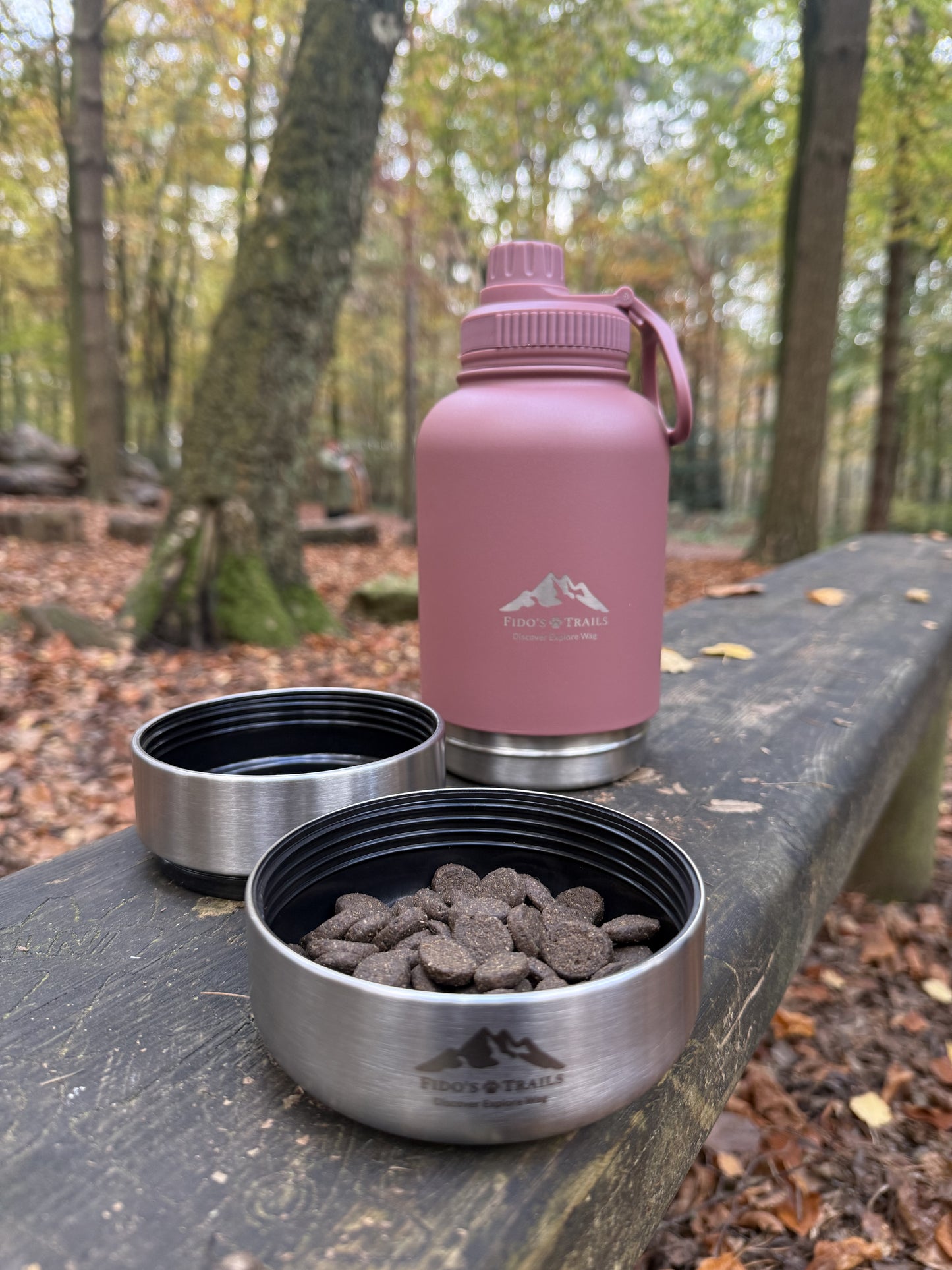 Dog eating from detachable bowl of Rosewood 3-in-1 water bottle outdoors