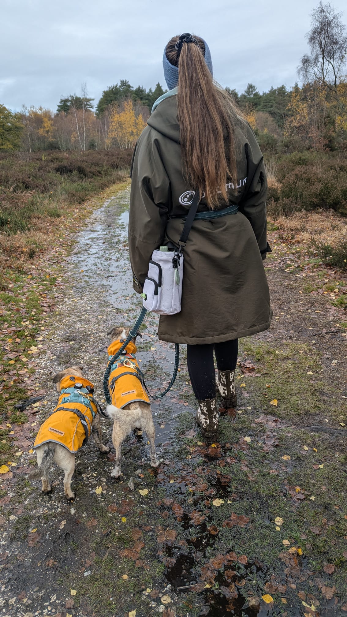Dog owner walking with hands-free water bottle bag, designed for comfortable outdoor adventures