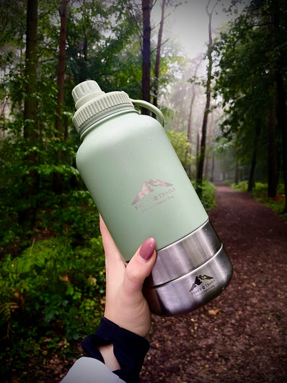 Portable 3-in-1 dog water bottle in Sage used outdoors during a forest walk
