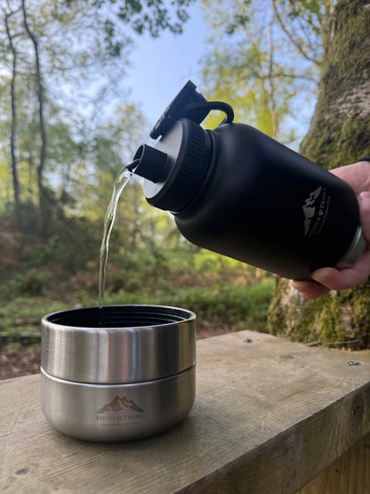 Black 3-in-1 dog water bottle pouring water into bowl during outdoor walk