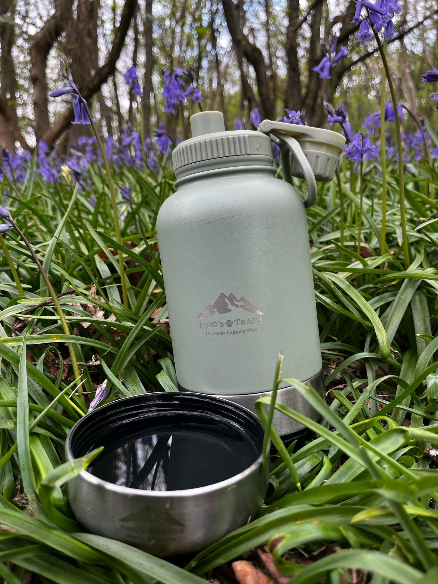 Sage 3-in-1 dog water bottle placed in grass during outdoor walk